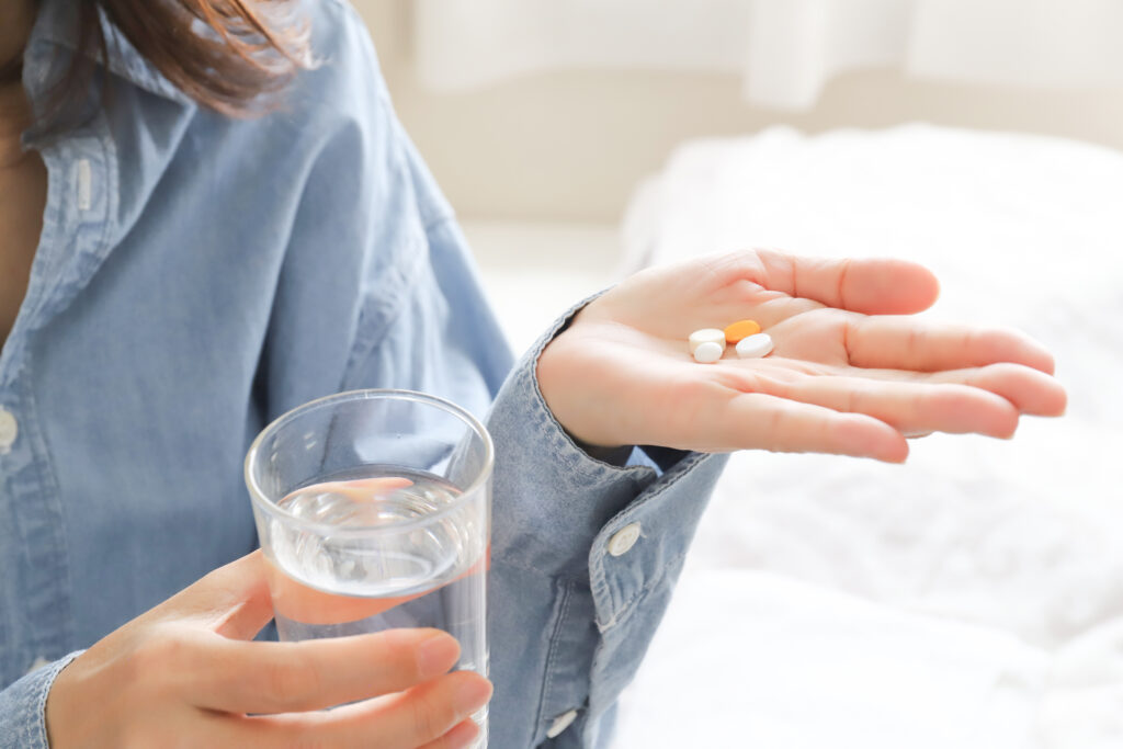 根管治療後に痛みが出て薬を服用する女性