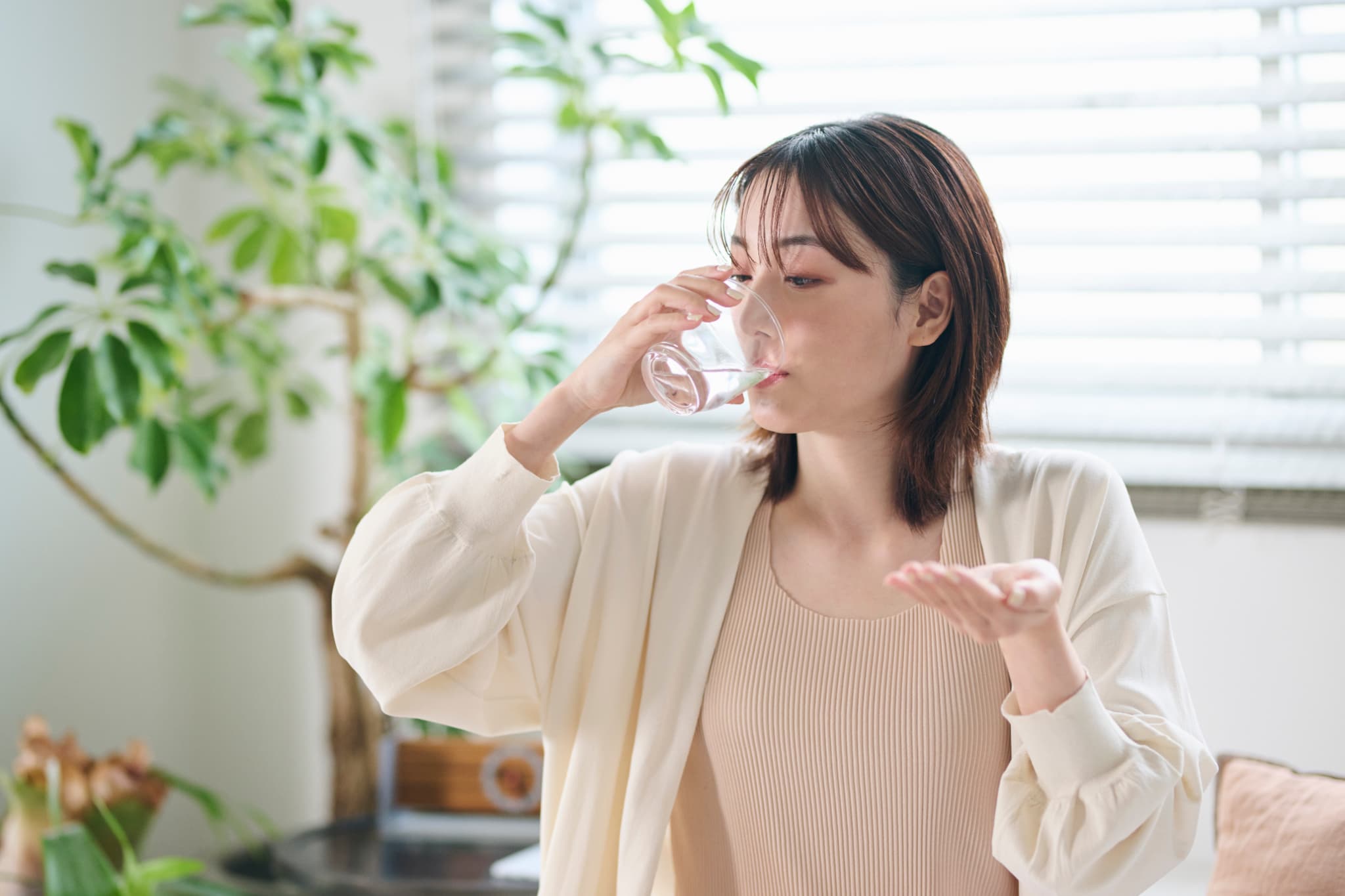 痛み止めを飲む女性