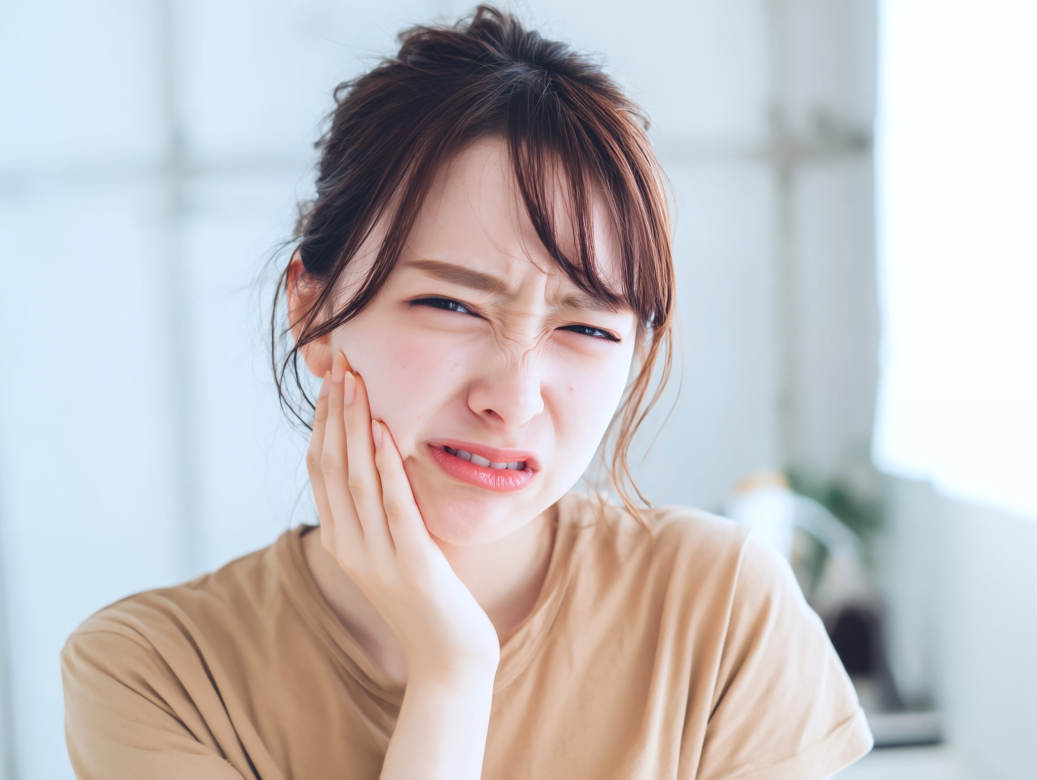前歯のインプラント治療後に歯が痛む女性