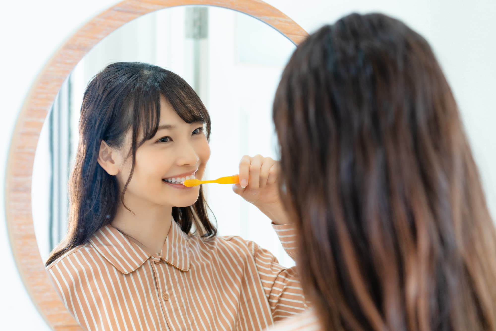 歯を失うのを防ぐために歯磨きを欠かさない女性