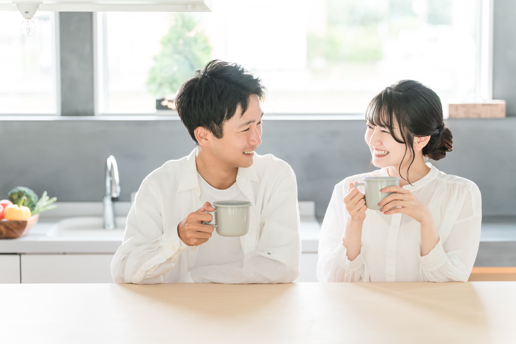 ダイニングでマグカップ片手に寛ぐ夫婦