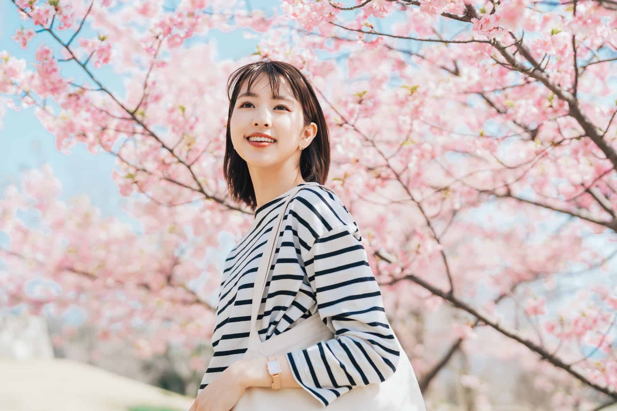 銀歯の下の虫歯を治療して笑顔で花見をする女性