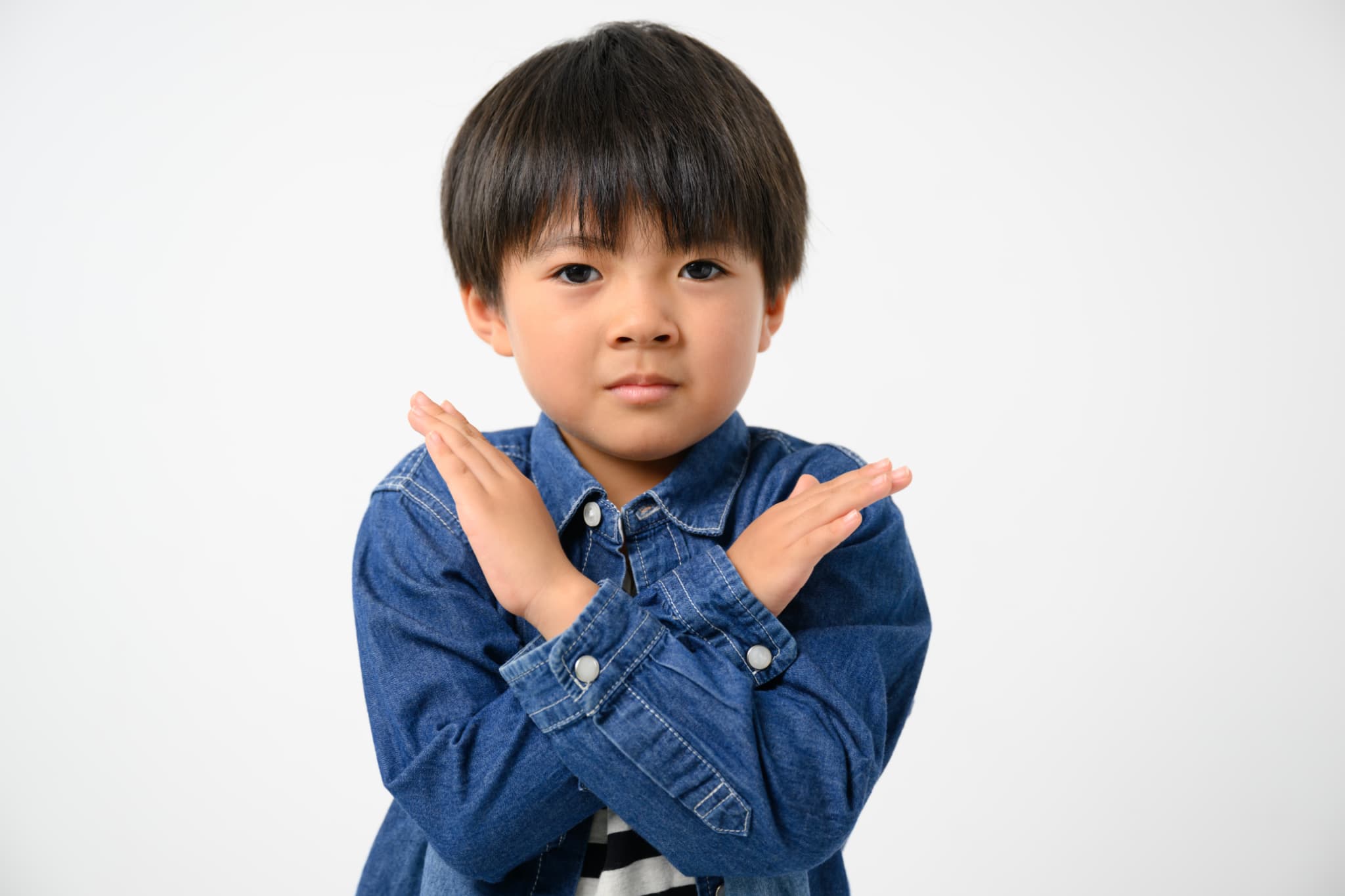 両手でバツマークを作る子ども